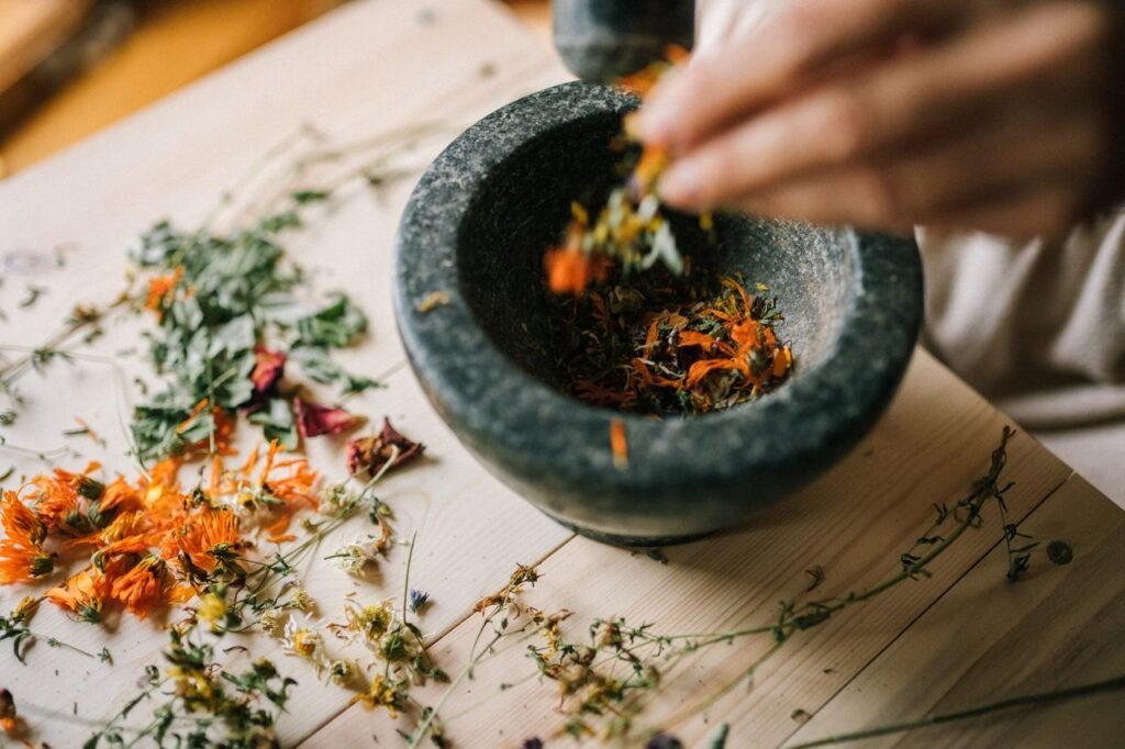 pexels-photo-5480057-5480057 Aromatic dried herbs being crushed in a stone mortar for culinary or medicinal use.